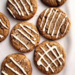 gingerbread latte cookies with crackled tops and a drizzle of creamy coffee icing arranged on parchment paper.