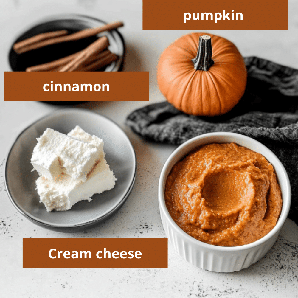 A flat lay of pumpkin dip ingredients including a small pumpkin, cream cheese cubes, cinnamon sticks, and a bowl of blended pumpkin mixture
