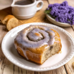 London Fog roll topped with Earl Grey vanilla glaze on a white plate with soft brioche crumb